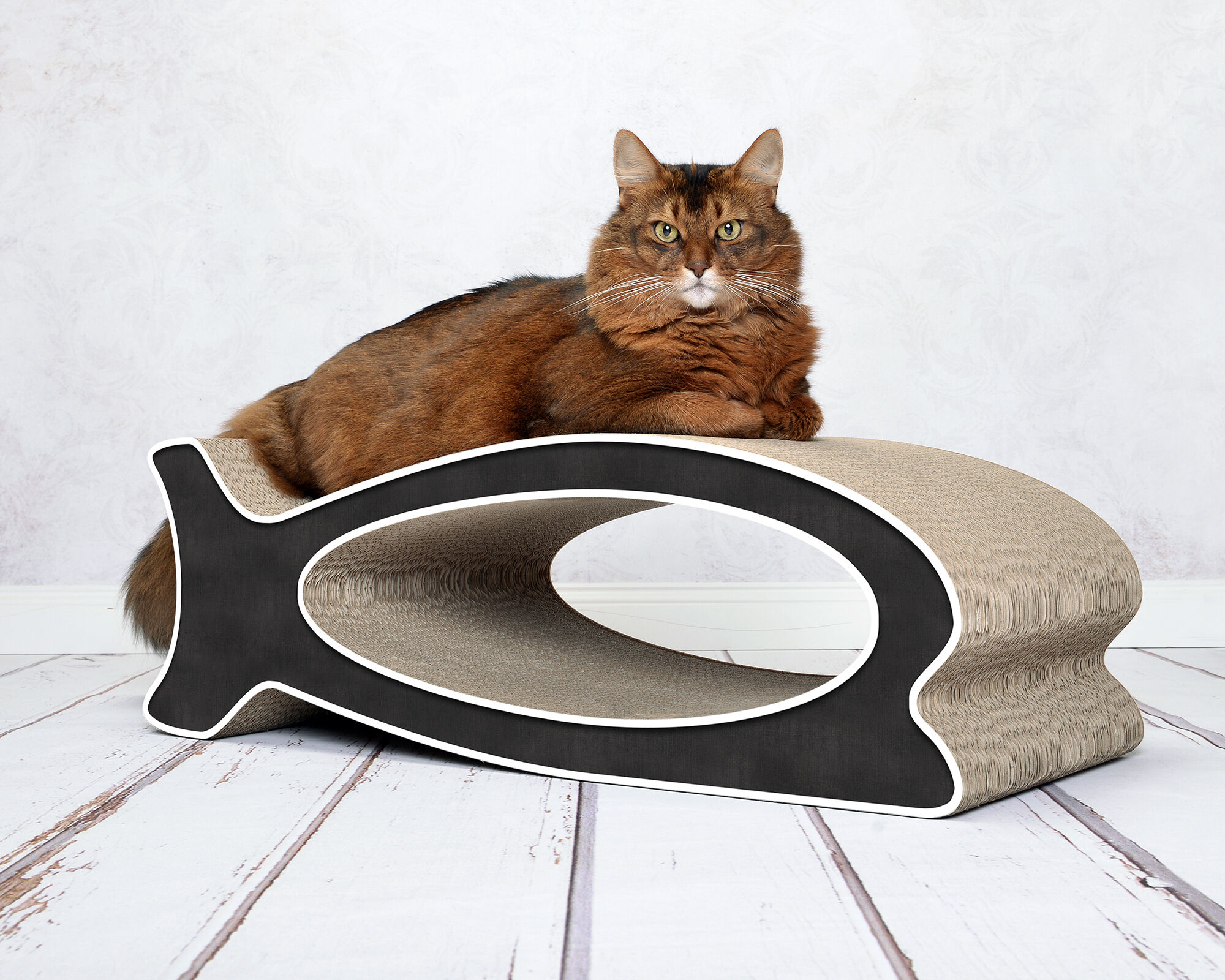 A cat playing and scratching on LE FISH – stylish fish-shaped cardboard cat scratcher